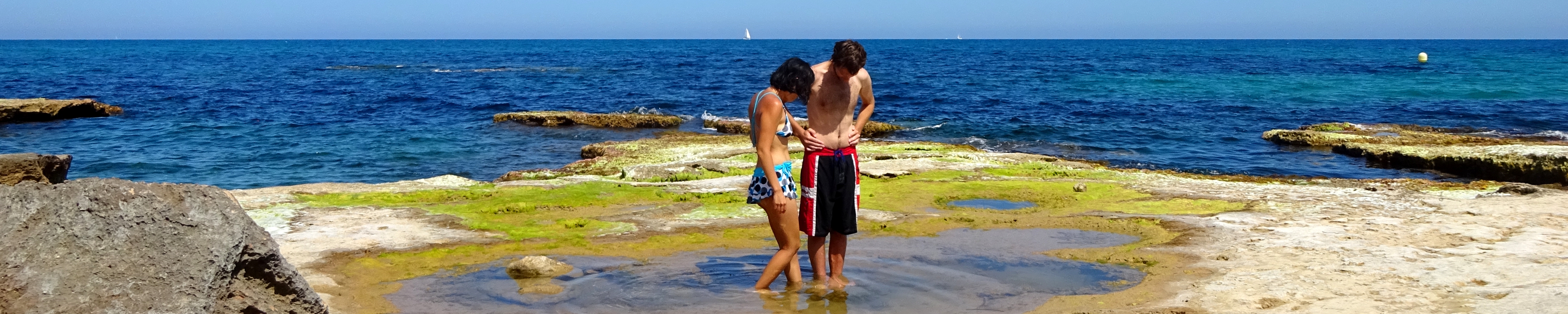 couple looking in a rockpool in Torrevieja, Spain